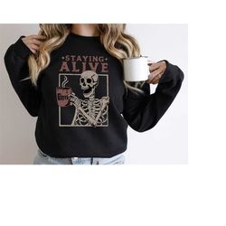 staying alive skeleton sweatshirt, staying alive skeleton sweatshirt gift for halloween, coffee addict skeleton sweatshi