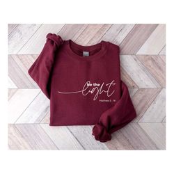 be the light sweatshirt, christian sweatshirt, bible verse shirts, woman christian clothing, faith shirt, matthew 5:14 s