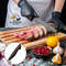 front-view-cook-apron-cutting-raw-fish-cutting-board-vegetables-wood-board-table (1).jpg