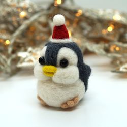 Miniature needle felted baby penguin in a Santa hat