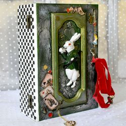 A green box with a white rabbit from Alice a box for cards or jewerly