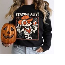 staying alive sweatshirt, halloween crewneck, funny skeleton hoodie, skeleton cowgirl shirt, cute spooky tee, fall sweat