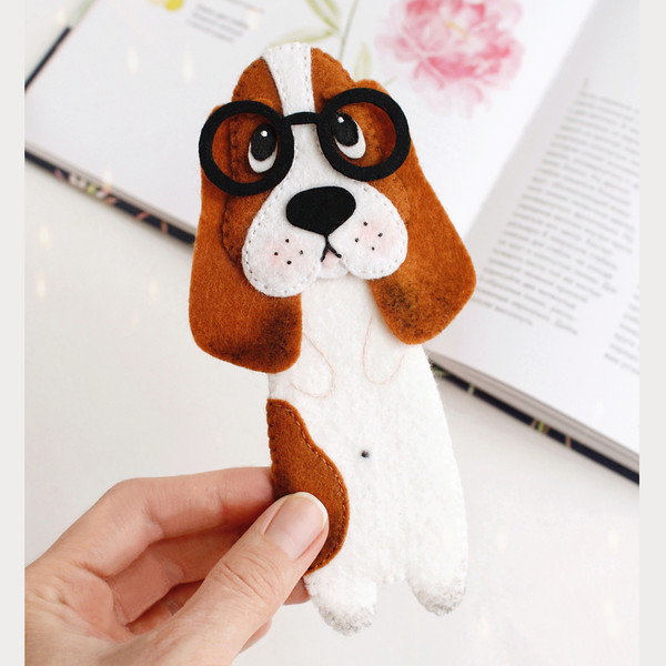 DIY felt hand sewn craft - kids long Basset hound in glasses bookmark in authors hand in front of the opened book