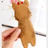 DIY felt hand sewn craft - kids long Yorkshire terrier dog hound bookmark in authors hand in front of the opened book, back side