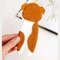 DIY felt hand sewn craft - kids long English bulldog breed bookmark in authors hand in front of the opened book, back side
