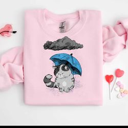 sad cat with umbrella cat in the rain