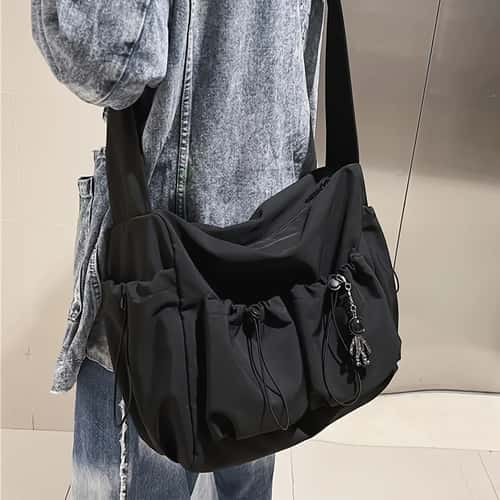 Fashionable Crossbody Bag with Drawstring Accent Spacious Zippered Closure & Stylish Bag Charm