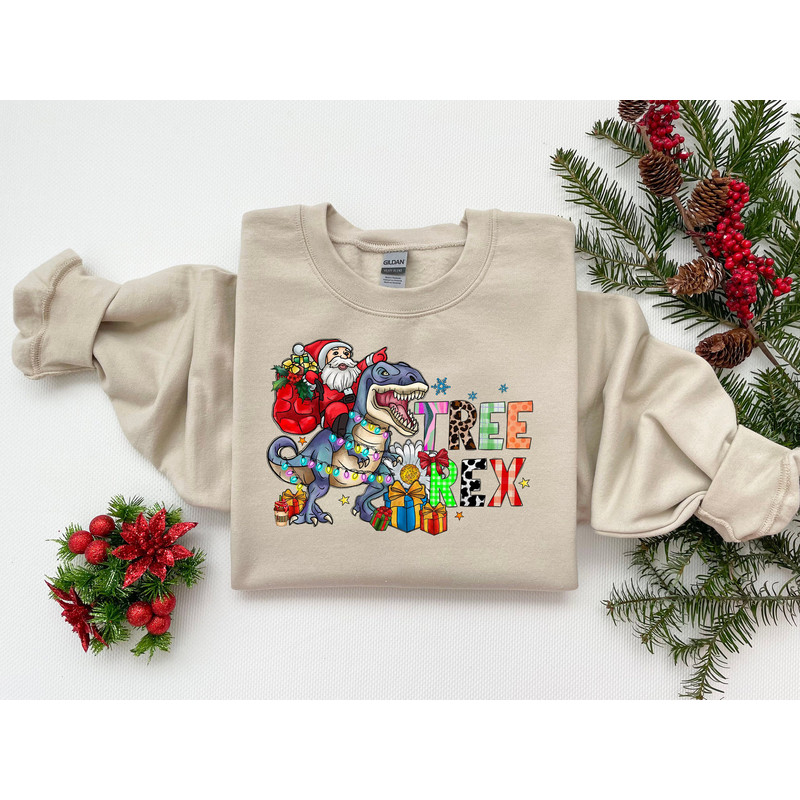 Christmas T-Rex Toddler Sweatshirt, Santa riding Dinosaur Christmas shirt, T-Rex Christmas Shirt, Funny Christmas Party Shirt Dino Lover Tee.jpg