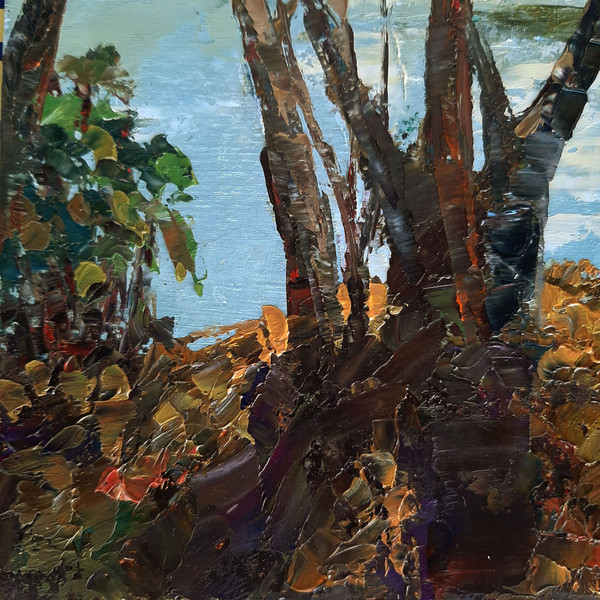 The long shadows of trees dancing across the yellow foliage on the riverbank. Fragment of a close-up Original River Landscape.