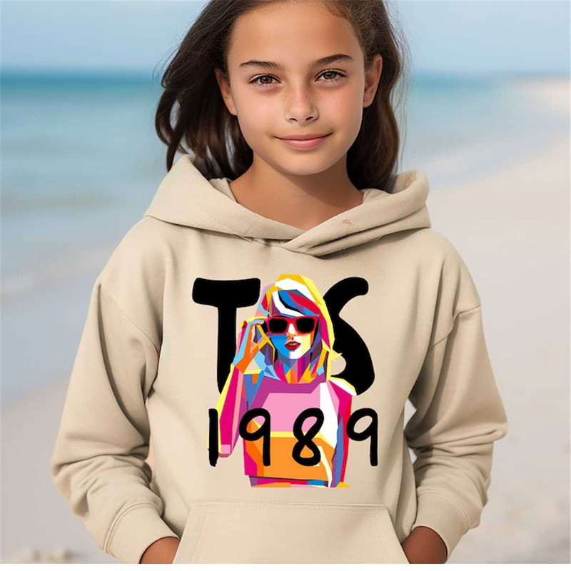 MR-2322024174740-a-young-girl-standing-on-a-beach-wearing-a-hoodie.jpg