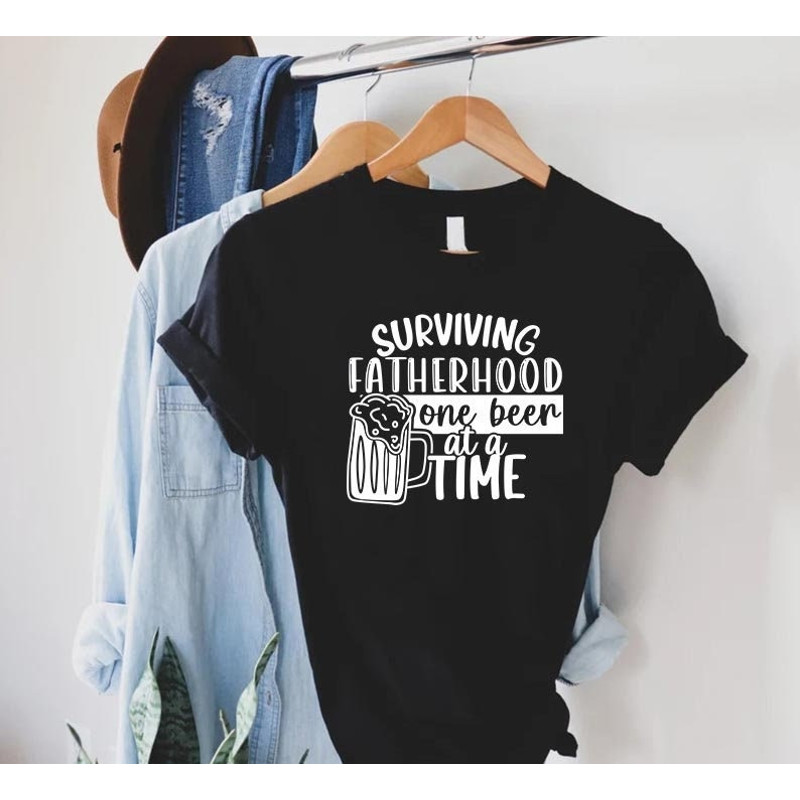 Funny Father Shirt,Fatherhood T-Shirt,Fathers Day Gift,Surviving Fatherhood One Beer At A Time,Best Dad Shirt,Dad Beer Shirt,Husband Gift.jpg