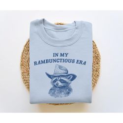 in my rambunctious era, funny sweatshirt, raccoon crewneck, meme sweatshirt, cartoon meme top, vintage cartoon sweater,