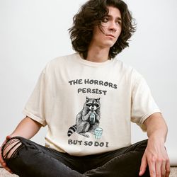 the horrors persist but so do i, funny shirts, silly gift, gag gift, trendy, raccoon shirt, cute raccoon shirt, unisex s