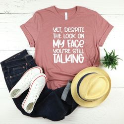 yet despite the look on my face you're still talking, funny shirts, shirts with sayings, funny t shirt, sarcastic tee