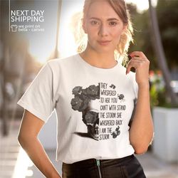 they whispered to her you can't withstand the storm she whispered back i am the storm v-neck shirt positive quote shirt