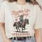 Buckle Up, Cowboy Graphic T-Shirt Life's a Rodeo Country Western Cowgirl Riding Horse Funny Retro Vintage Unisex Men's Women's Tee.jpg