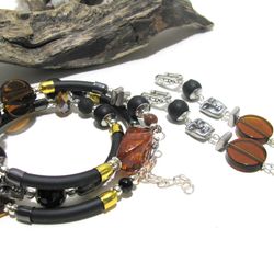 Trending contemporary style jewelry set of layered bracelet and earrings, black rubber bracelet
