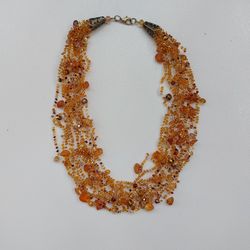 A small delicate airy layered necklace made of beads with amber, crocheted, a decoration for every day