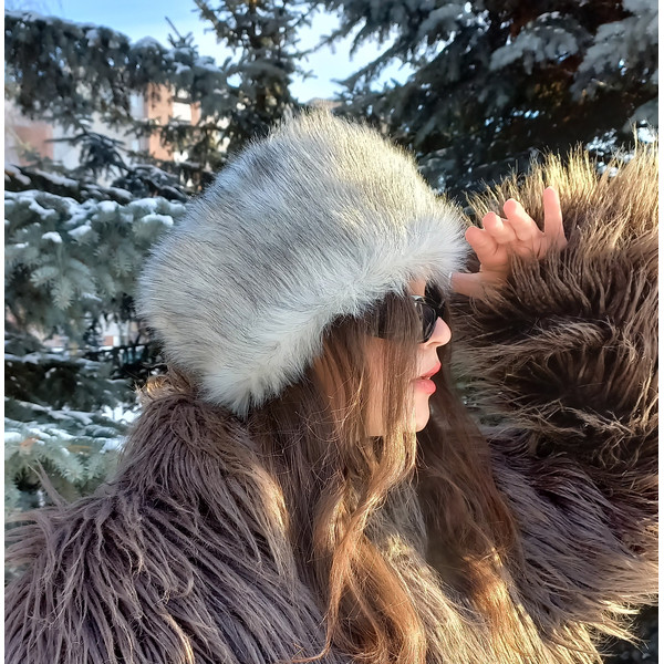 Arctic fox hat made of faux fur. Furry hat in russian style. Gray white fluffy hat.