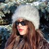 Arctic fox hat made of faux fur. Furry hat in russian style. Gray white fluffy hat.