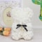 teddy bear covered in White roses