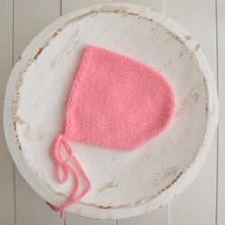 Newborn girl knitted salmon bonnet photo prop . Coral colour angora bonnet for new baby girl first photo shoot. Fuzzy ne