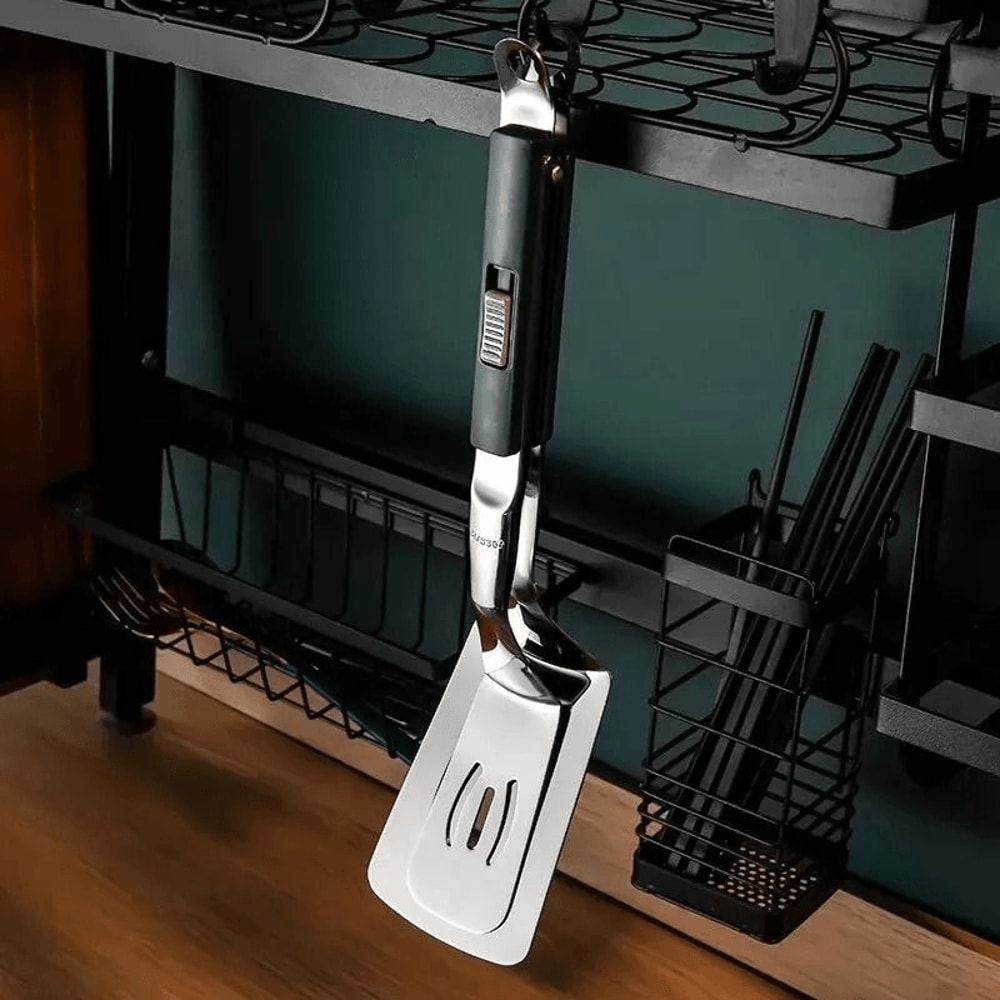 spatula tongs transferring food from skillet to plate