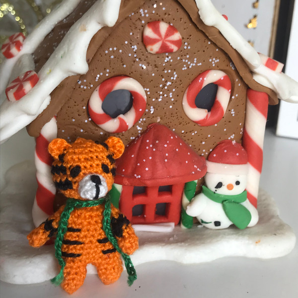 Tiger cub next to the gingerbread house